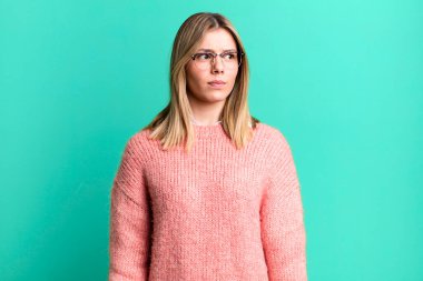 Sarışın, güzel bir kadın üzgün, üzgün ya da kızgın ve olumsuz bir tavır takınıyor, anlaşmazlık içinde kaşlarını çatıyor.