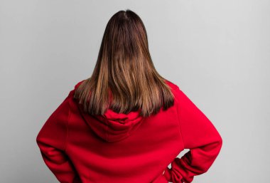 Güzel, genç bir kadın aklı karışık ya da dolu hissediyor ya da şüphe ve sorular, merak ediyor, elleri kalçasında, dikiz aynasından.