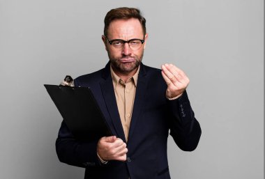 middle age man making capice or money gesture, telling you to pay with an inventory. business concept