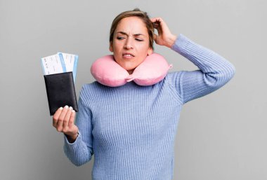 Güzel sarışın kadın şaşkın ve kafası karışık, kaşınıyor. uçuş yolcu kavramı