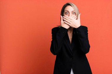 pretty blonde woman covering mouth with hands with a shocked. businesswoman concept