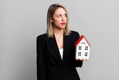 pretty blonde woman feeling sad, upset or angry and looking to the side. real state concept