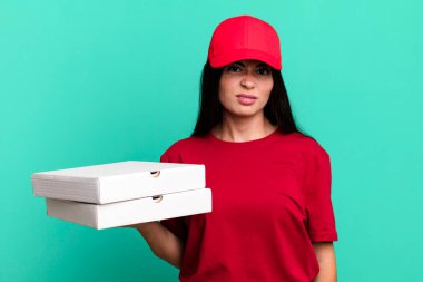 hispanic pretty woman feeling puzzled and confused. delivery pizza concept
