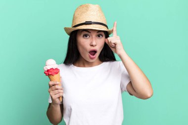 hispanic pretty woman looking surprised, realizing a new thought, idea or concept. ice cream and summer concept