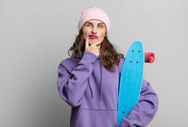 hispanic pretty woman thinking, feeling doubtful and confused. skate boarding concept