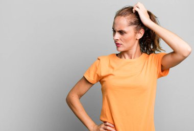 İspanyol güzel kadın şaşkın ve kafası karışık, kaşınan bir kafa hissediyor. boşluk konseptini kopyala