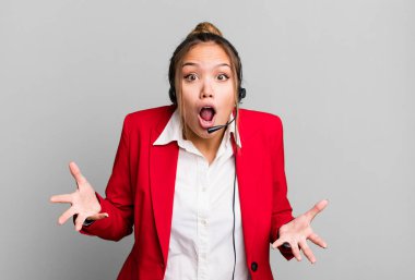 hispanic pretty woman amazed, shocked and astonished with an unbelievable surprise. telemarketing concept