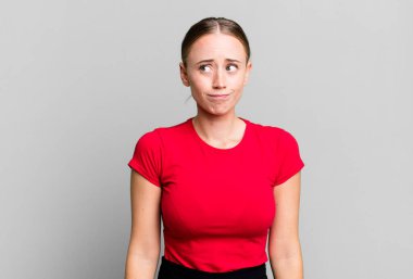 Şaşırmış ve kafası karışmış görünüyor, merak ediyor ya da bir sorunu çözmeye çalışıyor.