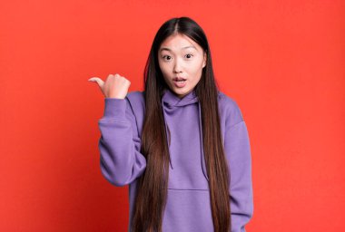 Genç, güzel, Asyalı, etkileyici bir kadın. Yanında fotokopi odası var.