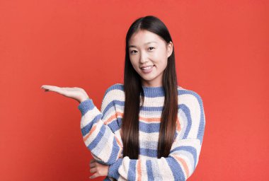 Genç, güzel, Asyalı, etkileyici bir kadın. Yanında fotokopi odası var.