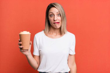 pretty blonde woman looking puzzled and confused with a hot coffee