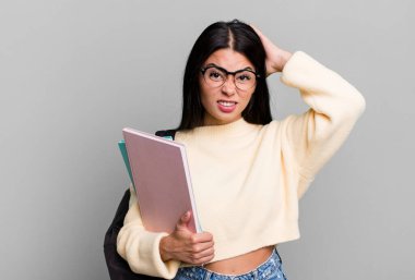 hispanic pretty woman feeling stressed, anxious or scared, with hands on head. university student concept