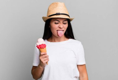 hispanic pretty woman with cheerful and rebellious attitude, joking and sticking tongue out. ice cream and summer concept