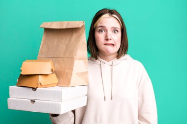 young pretty woman looking puzzled and confused. take away fast food concept