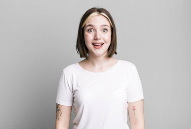 Genç ve güzel bir kadın mutlu ve hoş bir şekilde şaşırmış görünüyor.