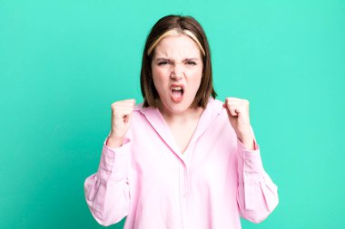 Genç ve güzel bir kadın sinirli bir ifadeyle bağırıyor.