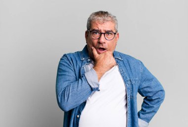 Orta yaşlı, ağzı ve gözleri açık ve eli çenesinde olan son sınıf öğrencisi. Hoş olmayan bir şok geçiriyor.