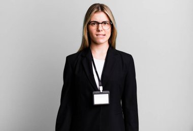 young pretty woman looking puzzled and confused. id card accreditation concept