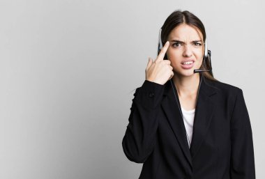 young pretty woman feeling confused and puzzled, showing you are insane. telemarketing agent concept