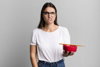 young pretty woman looking puzzled and confused. japanese ramen noodles concept