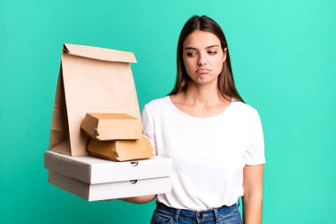 young pretty woman feeling sad, upset or angry and looking to the side. delivery and take away concept