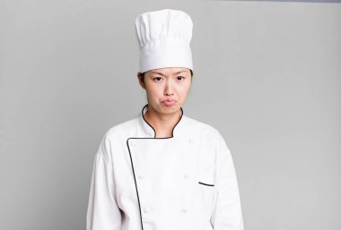 pretty asian woman feeling sad and whiney with an unhappy look and crying. restaurant chef concept