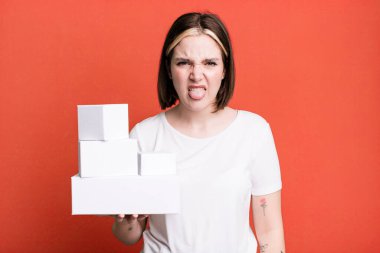 young pretty woman feeling disgusted and irritated and tongue out. white blank boxes