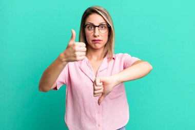 blonde adult woman feeling confused, clueless and unsure, weighting the good and bad in different options or choices