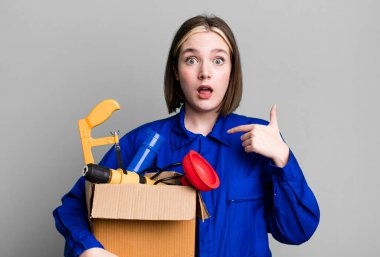 young pretty woman feeling happy and pointing to self with an excited. housekeeper and toolbox concept