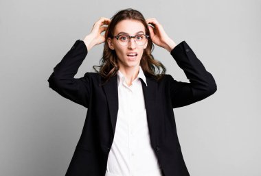 Genç ve güzel bir kadın gergin, endişeli ya da korkmuş hissediyor. Elleri başının üstünde. iş kavramı