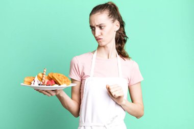 Genç, güzel bir kadın üzgün, üzgün ya da kızgın hissediyor ve yan tarafa bakıyor. Waffle konsepti