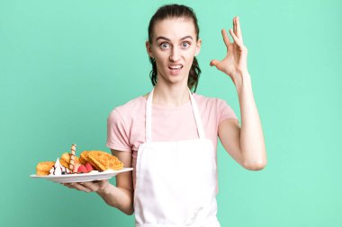 Genç ve güzel bir kadın ellerini havaya kaldırarak çığlık atıyor. Waffle konsepti