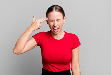 Mutsuz ve stresli görünüyor, intihar jesti elle silah işareti yapıyor, kafasını işaret ediyor.