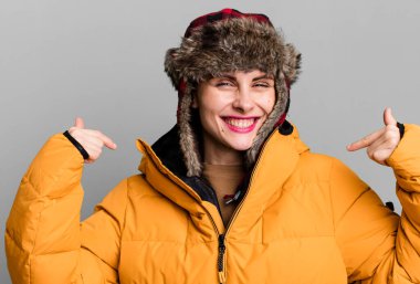 Anorak ve kış şapkası takan genç ve güzel bir kadın.