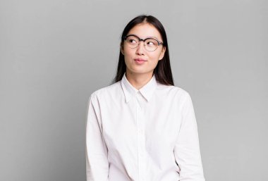 Genç, güzel, Asyalı, etkileyici bir kadın. Yanında fotokopi odası var.