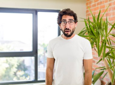 young adult crazy man with expressive pose at a modern house interior