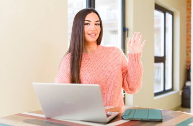 pretty young woman with a laptop on a desk  at home