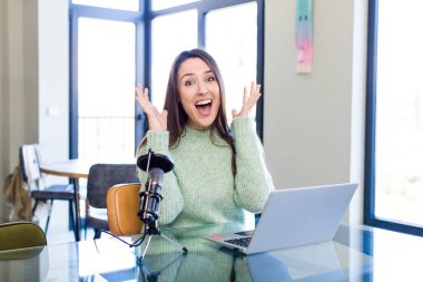 young pretty woman feeling happy and astonished at something unbelievable. influencer concept