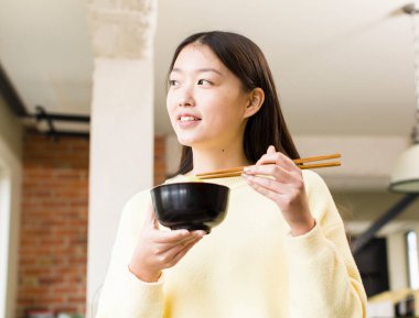 Asyalı güzel kadın ramen kasesi yiyor.