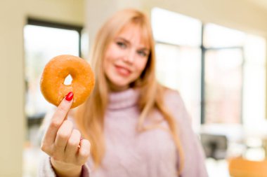 Donutlu genç ve güzel bir kadın. İç mekanda sağlıksız diyet kavramı