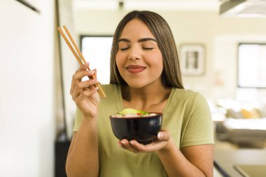 Güzel Latin kadın ramen kasesi yiyor.