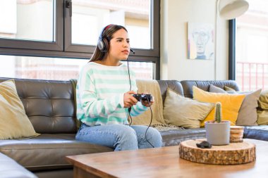 pretty latin woman playing with headset and controller. gamer concept