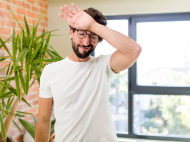 young adult crazy man with expressive pose at a modern house interior