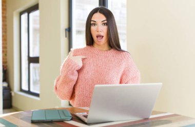 pretty young woman with a laptop on a desk  at home