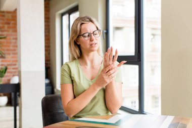 Genç, güzel bir kadın endişeli, hasta ve mutsuz hissediyor. Acılı bir el ağrısı çekiyor.