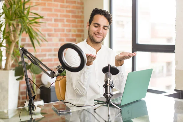 Joven Hispano Sosteniendo Objeto Con Ambas Manos Espacio Copia Mostrando — Foto de Stock