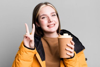 young pretty woman with a coat and a take away coffee