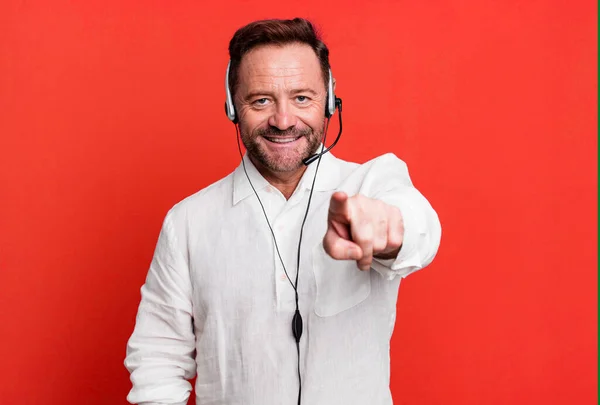 middle age man pointing at camera choosing you. telemarketer concept