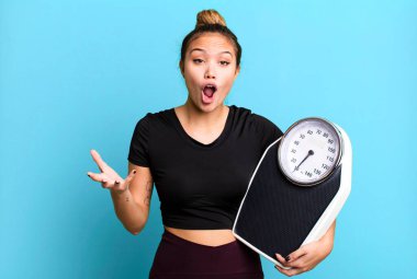 hispanic pretty woman amazed, shocked and astonished with an unbelievable surprise. fitness and diet concept