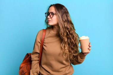 Profil görünümlü İspanyol güzel kadın hayal mi kuruyor, hayal mi kuruyor, hayal mi kuruyor? kahve konseptini kaldır.